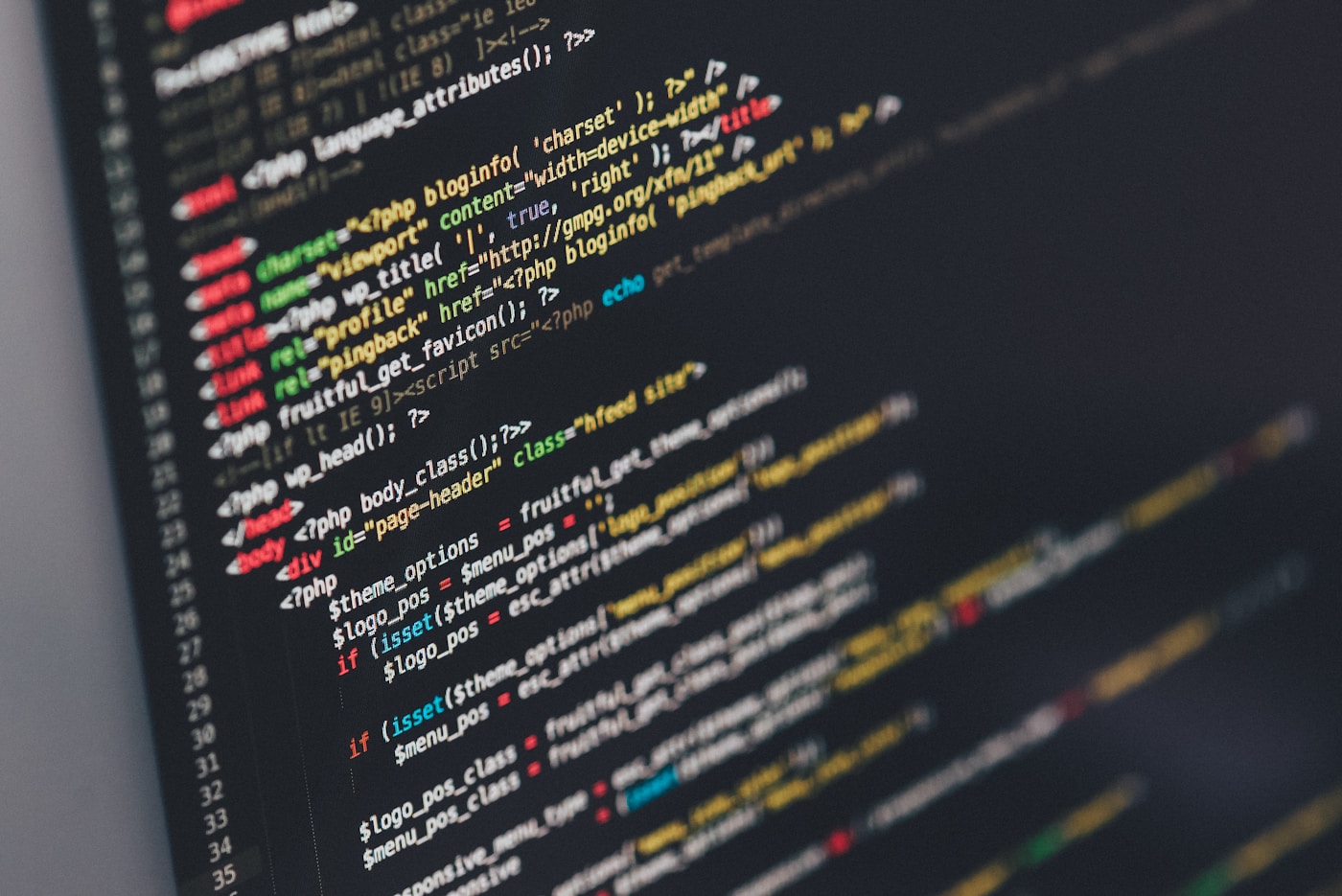 Developer coding on a laptop with multiple screens