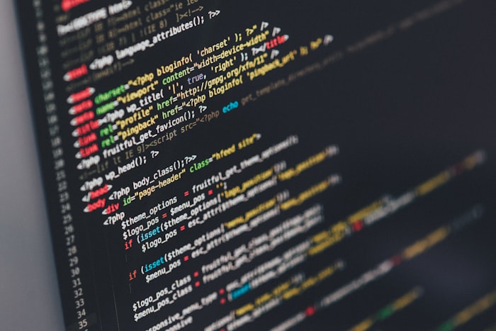 Developer coding on a laptop with multiple screens
